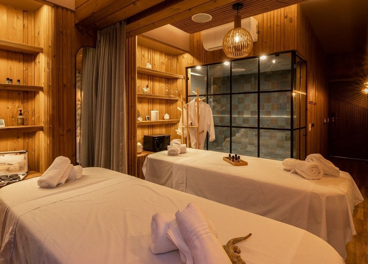 Elegant massage room at Celestino Spa, Medellín, Antioquia, CO, featuring wooden decor and cozy ambiance.