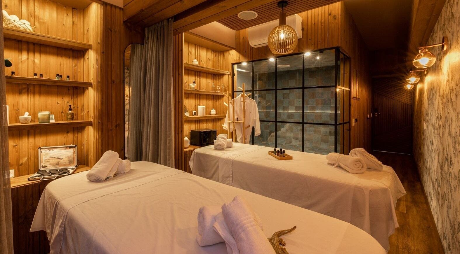 Elegant massage room at Celestino Spa, Medellín, Antioquia, CO, featuring wooden decor and cozy ambiance.