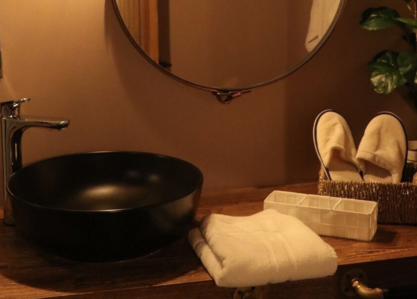 Elegant vanity setup at Celestino Spa, Medellín, Antioquia, CO featuring plush towels and cozy slippers.