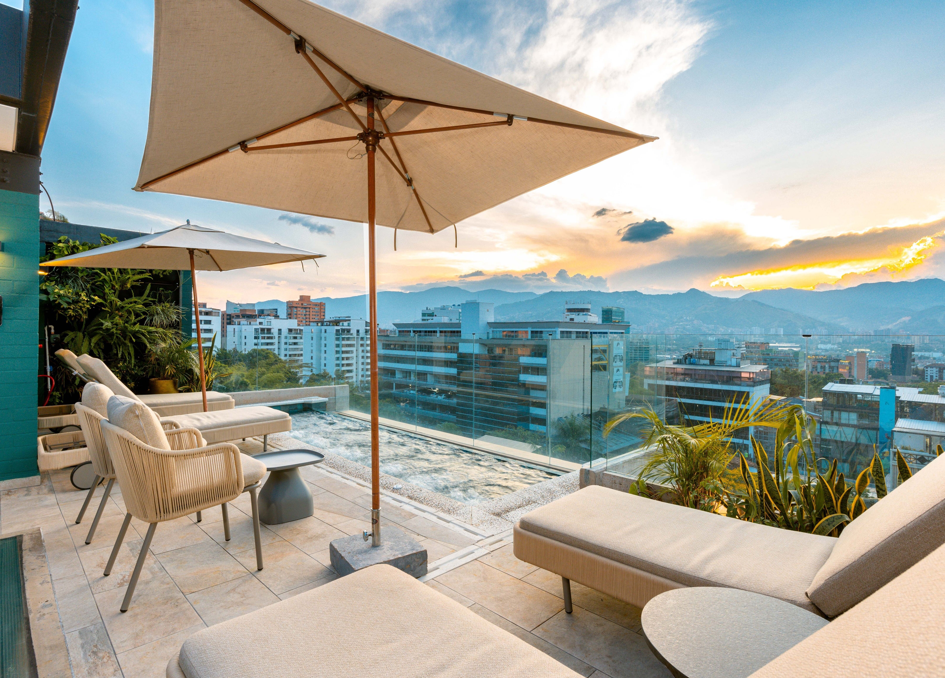 Rooftop view from Celestino Spa in Medellín, Antioquia, CO, showcasing sunset and city skyline.