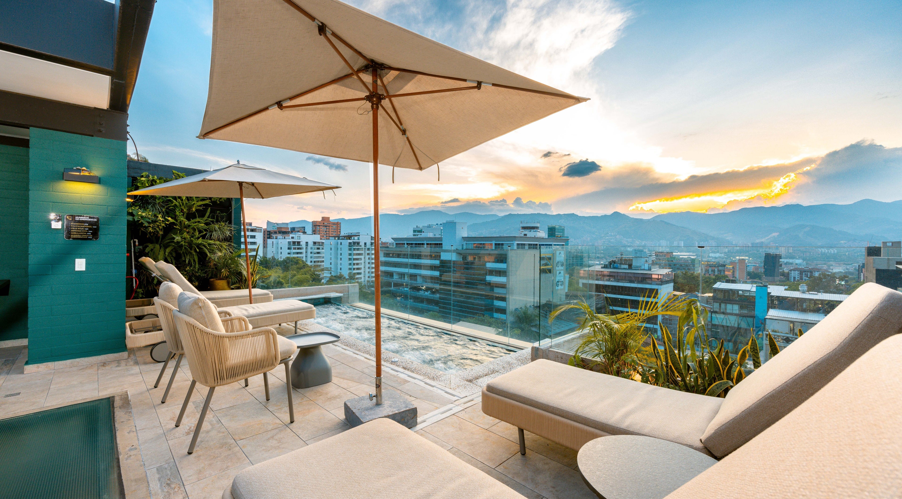 Rooftop view from Celestino Spa in Medellín, Antioquia, CO, showcasing sunset and city skyline.