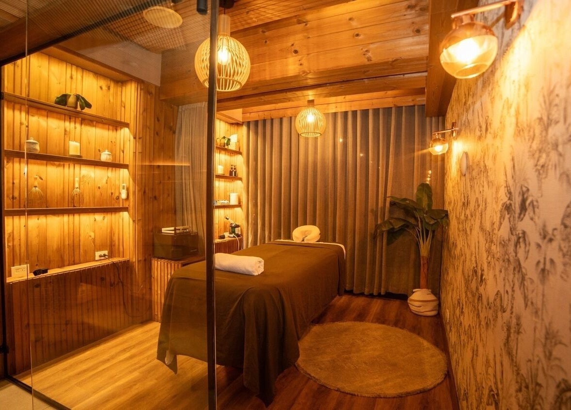 Peaceful massage room at Celestino Spa, Medellín, Antioquia, CO with warm lighting and wooden decor.
