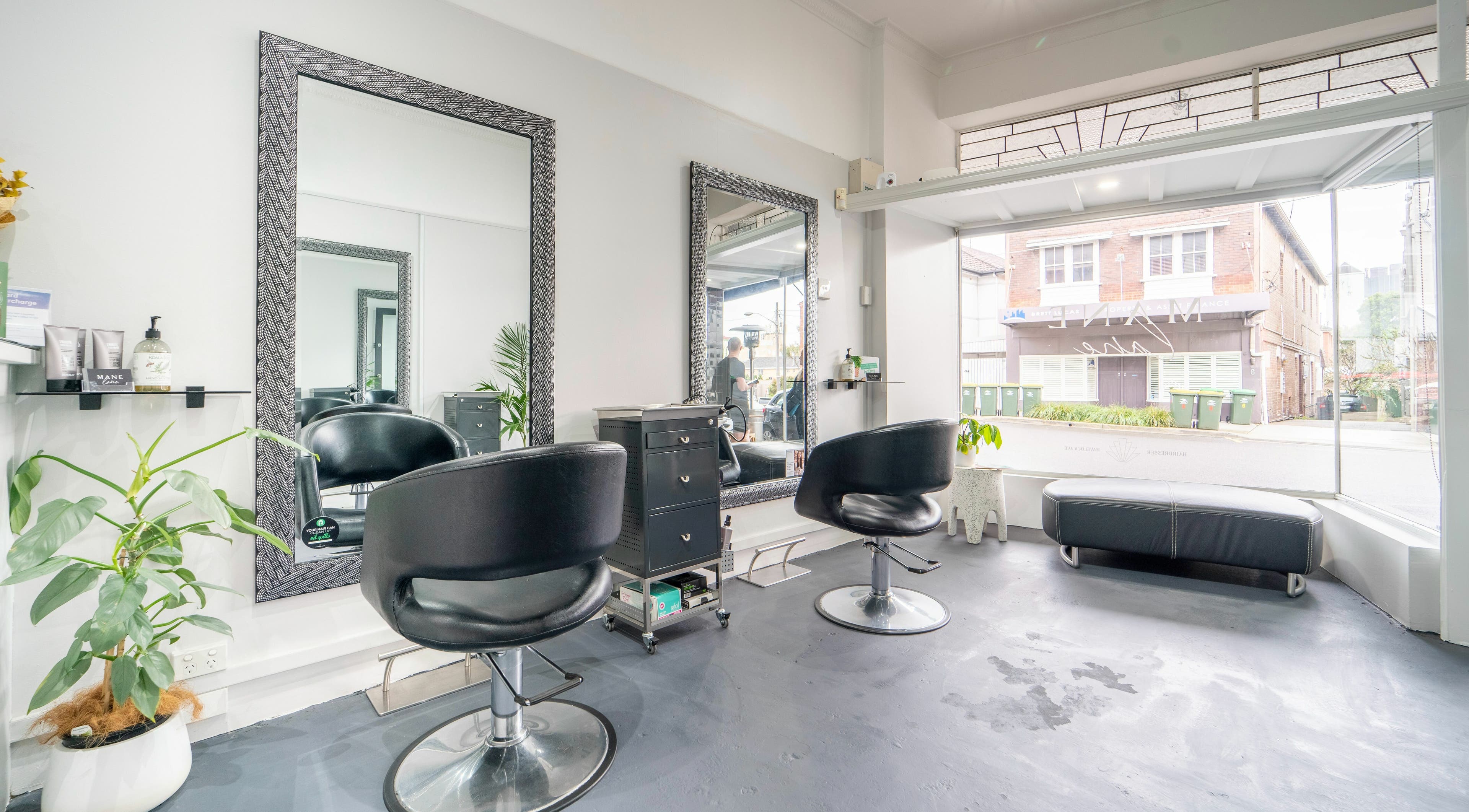 Modern and inviting interior of Mane Lane salon in Coogee, New South Wales, AU featuring stylish chairs and mirrors.