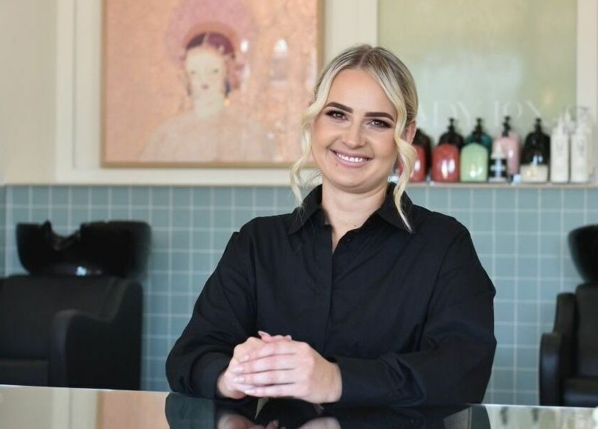 Smiling staff member at Lady Lox, Joondalup, Western Australia, AU, in a stylish salon setting.