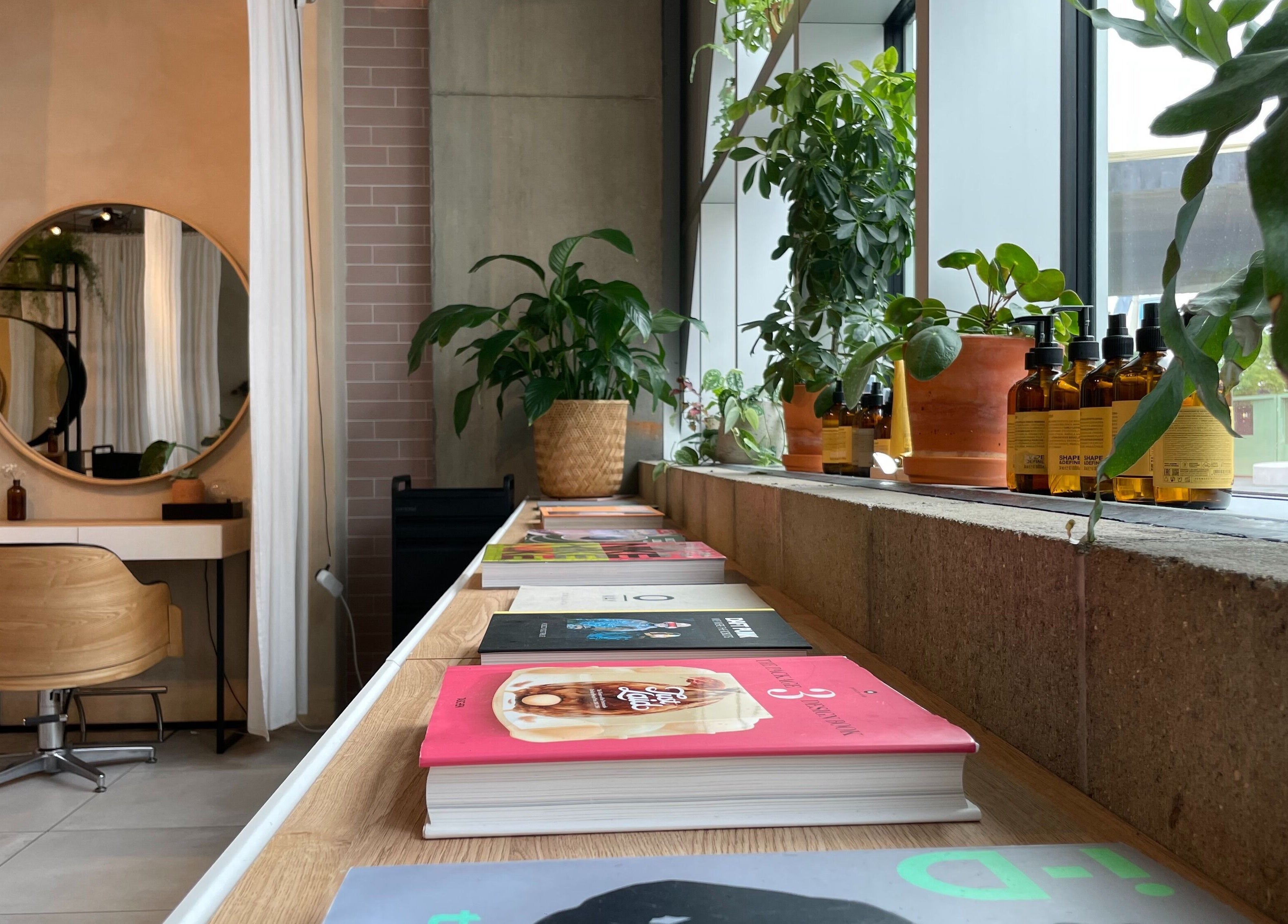 Cozy beauty station at Stanley Watts, London, England, GB with wooden chair, mirror, books, and plants.