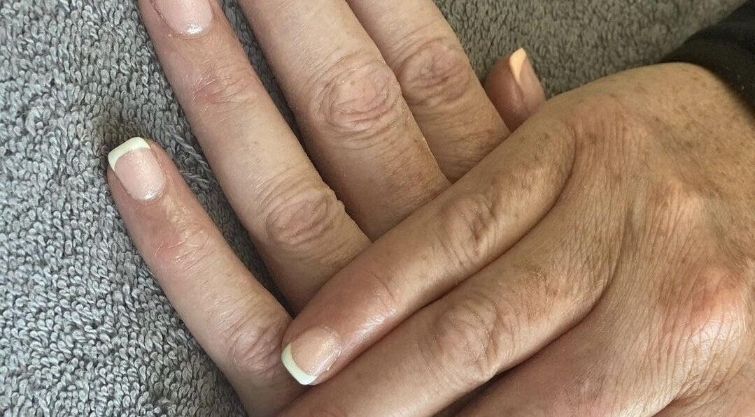 Beautiful French manicure at Ego Nails & Beauty in Workington, England, GB showcased on a hand resting on a towel.