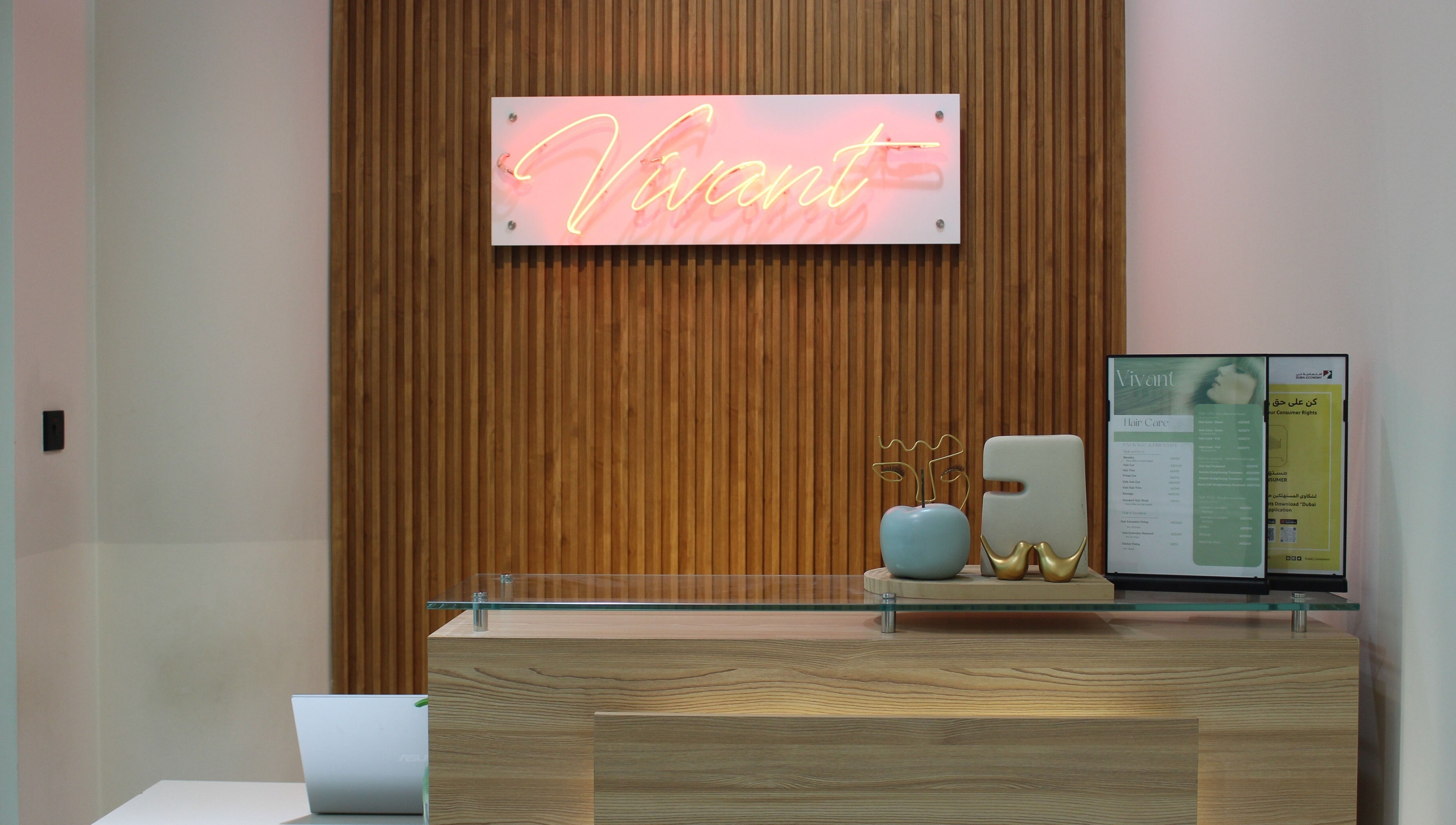 Reception area at Vivant Beauty Salon, Dubai, Dubai, AE with a neon sign and modern decor.