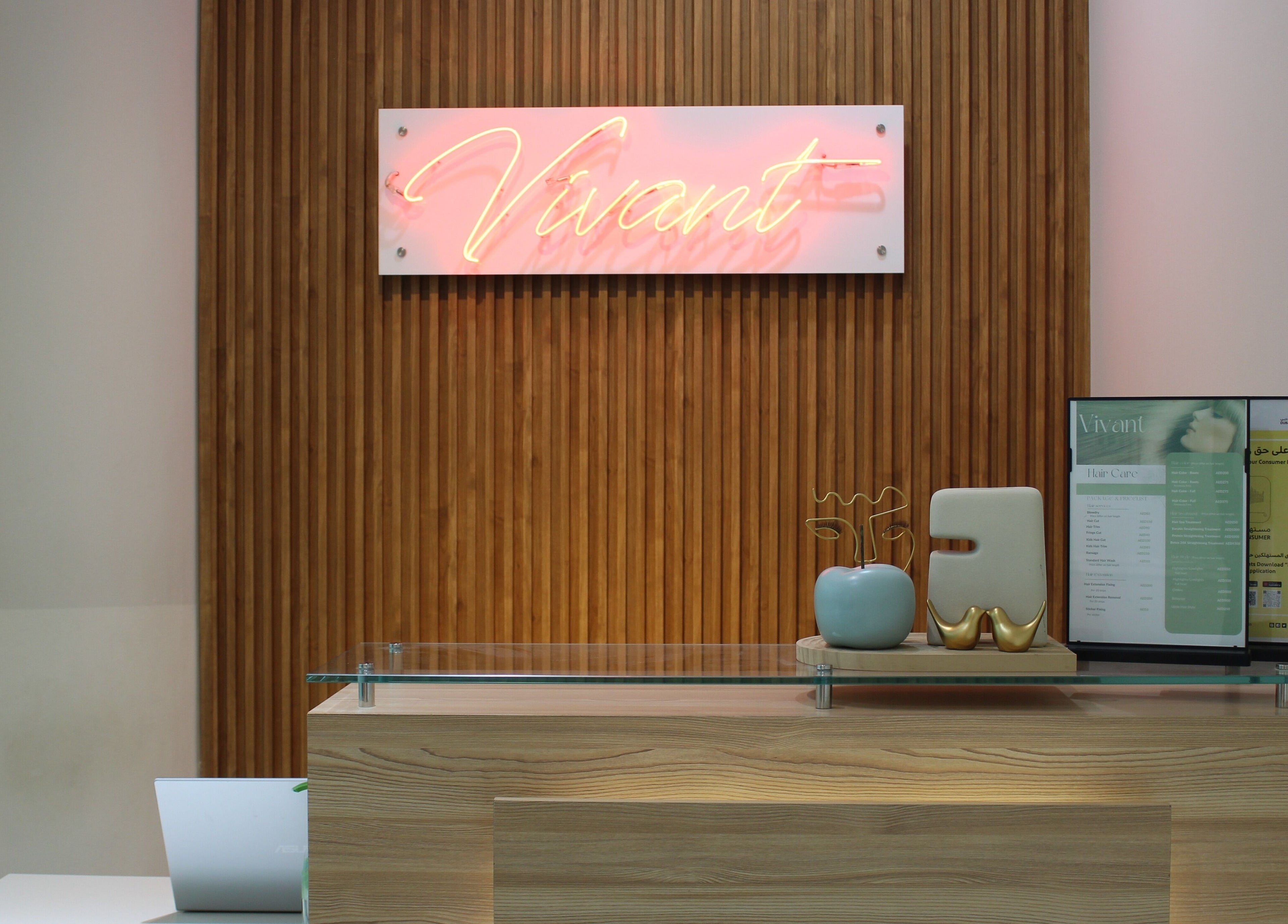 Reception area at Vivant Beauty Salon, Dubai, Dubai, AE with a neon sign and modern decor.