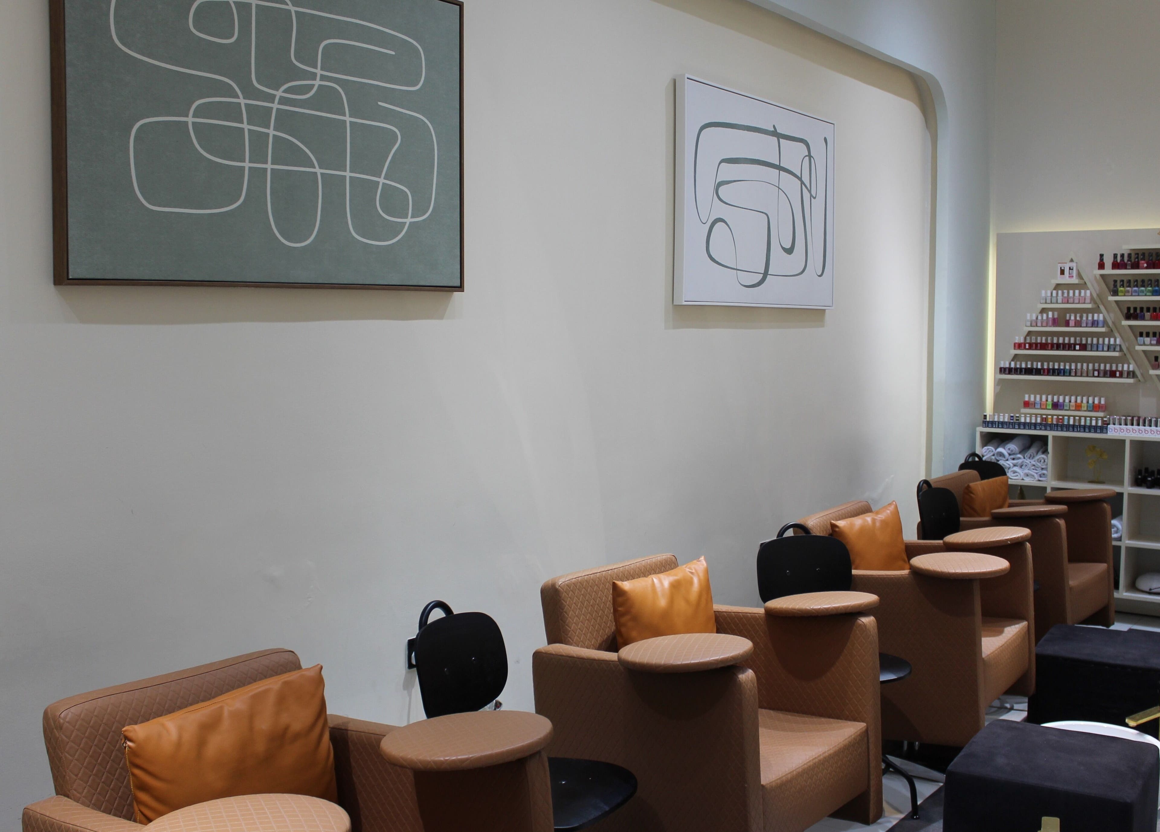 Cozy seating at Vivant Beauty Salon, Dubai, Dubai, AE, with nail polish displays and modern art.