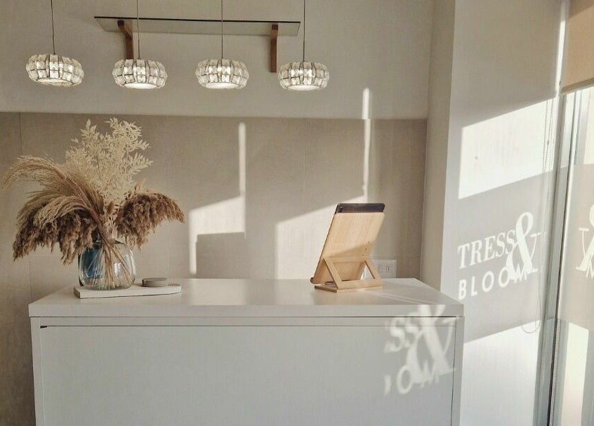 Chic reception area of Tress and Bloom Neath, Neath, Wales, GB with soft lighting and decorative vase.
