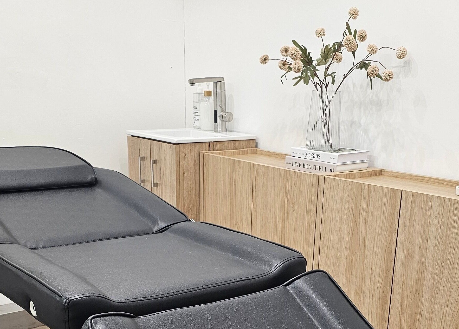 Treatment room at Tress and Bloom Ystradgynlais, Ystradgynlais, Wales, GB with a plush black chair and elegant decor.