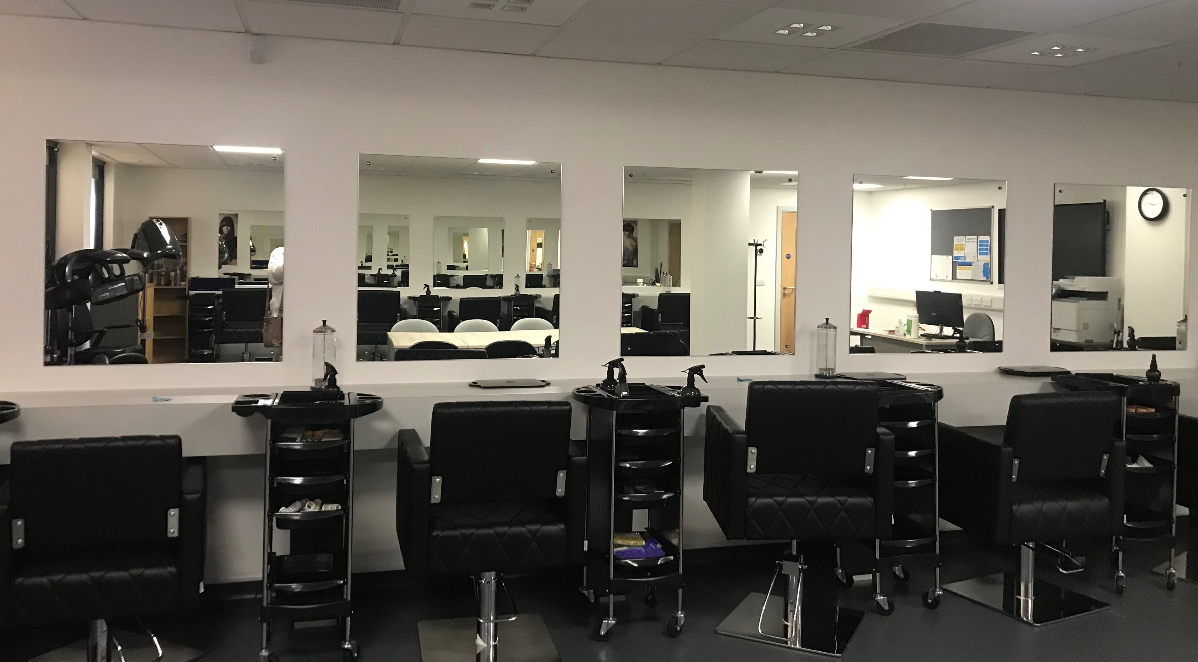 Modern setup at Skills and Learning Barbering Training Salon in Poole, England, GB featuring sleek styling chairs.