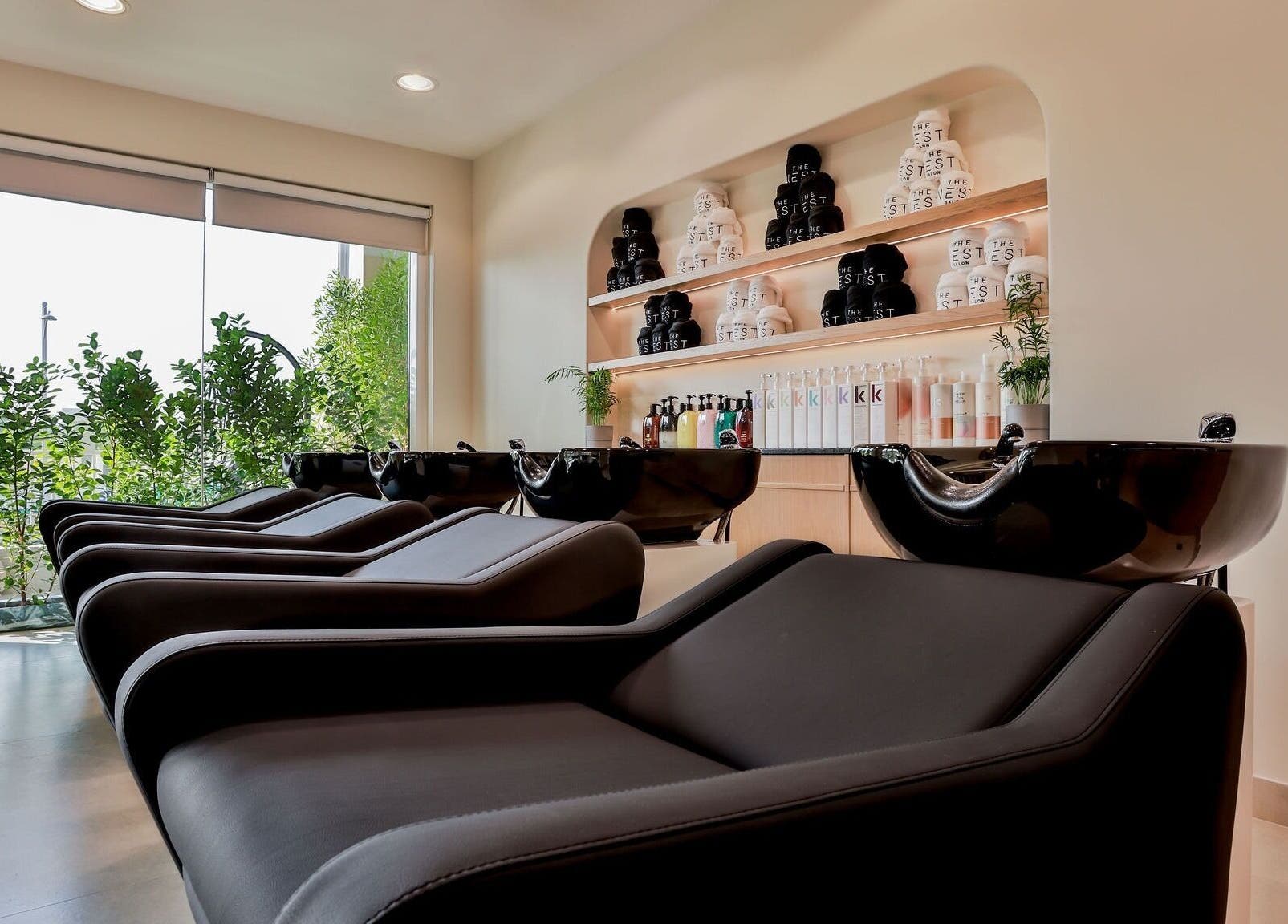 Elegant hair wash station at The Nest Hair Salon, Jumeirah, Dubai, AE with modern black chairs.
