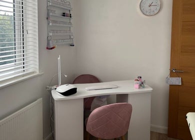 Orchid Beauty nail station in Crawley, England, GB featuring a chic manicure setup with pink chairs.