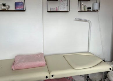 Treatment table in Orchid Beauty, Crawley, England, GB. Shelves with products adorn the wall.