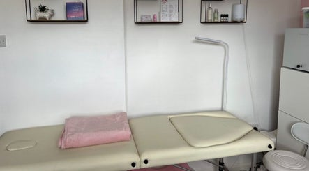Treatment table in Orchid Beauty, Crawley, England, GB. Shelves with products adorn the wall.