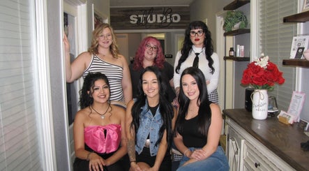 Group of stylists smiling at Studio ELL.B in Texarkana, Texas, US. Bright, welcoming salon environment.