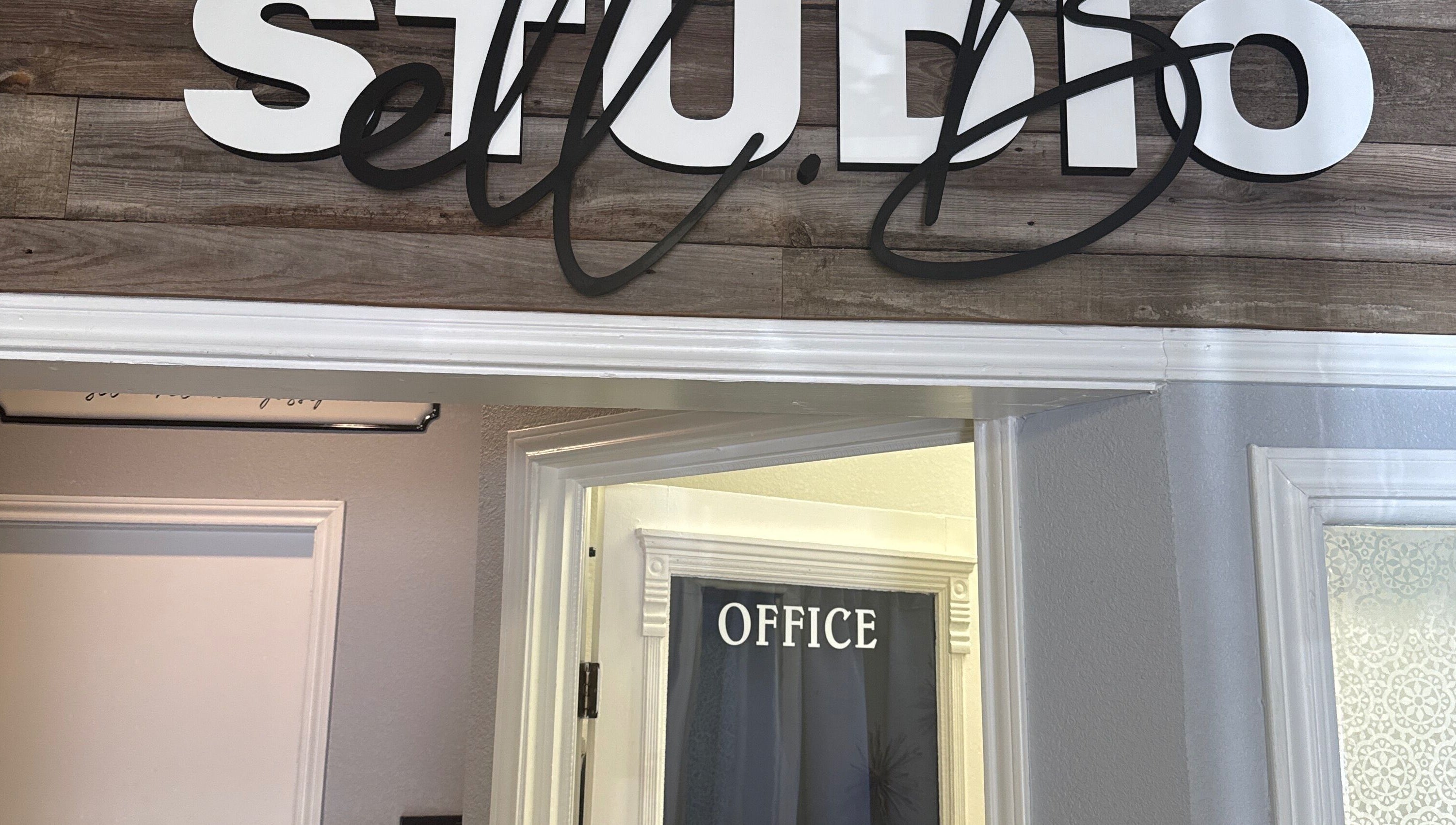 Entrance of Studio ELL.B with office sign at Texarkana, Texas, US showcasing rustic wood decor.