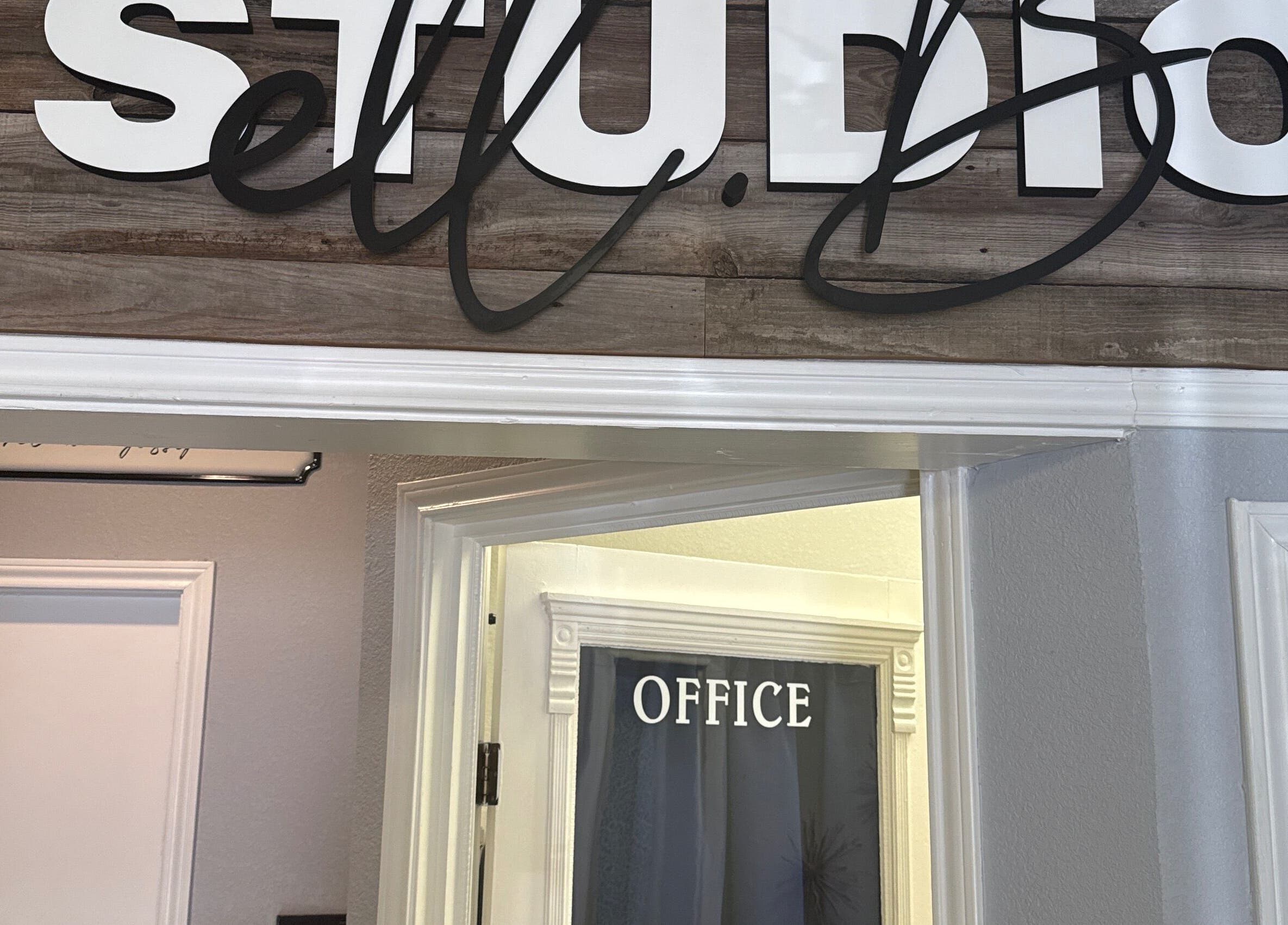 Entrance of Studio ELL.B with office sign at Texarkana, Texas, US showcasing rustic wood decor.