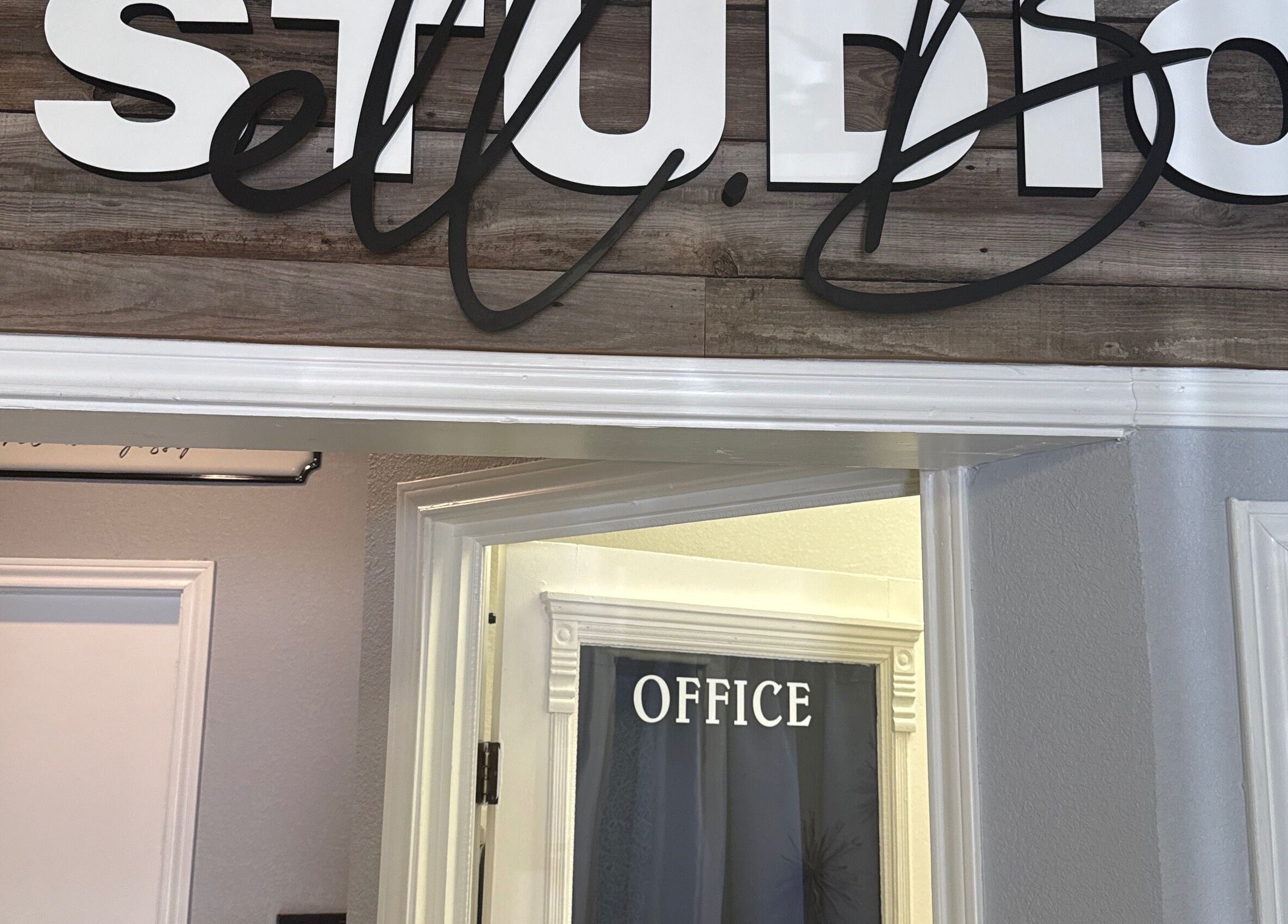 Entrance of Studio ELL.B with office sign at Texarkana, Texas, US showcasing rustic wood decor.