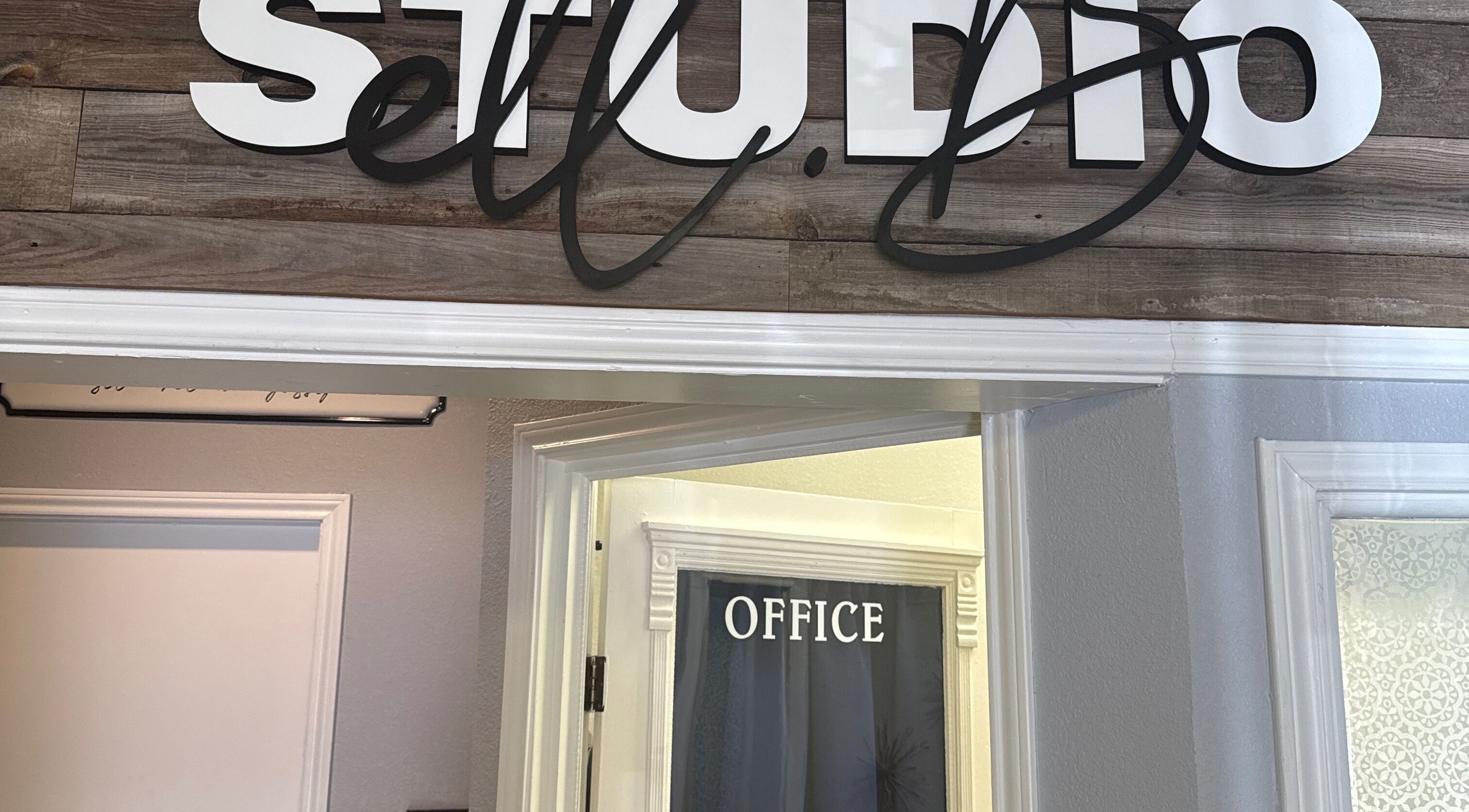 Entrance of Studio ELL.B with office sign at Texarkana, Texas, US showcasing rustic wood decor.