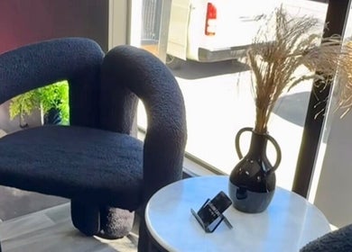 A cozy seating area at Aio Skin (Friday Glow) in Kawakawa, Northland, NZ with a modern chair and vase.