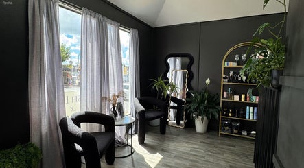 Elegant interior of Aio Skin (Friday Glow) in Kawakawa, Northland, NZ featuring modern black chairs and plants.