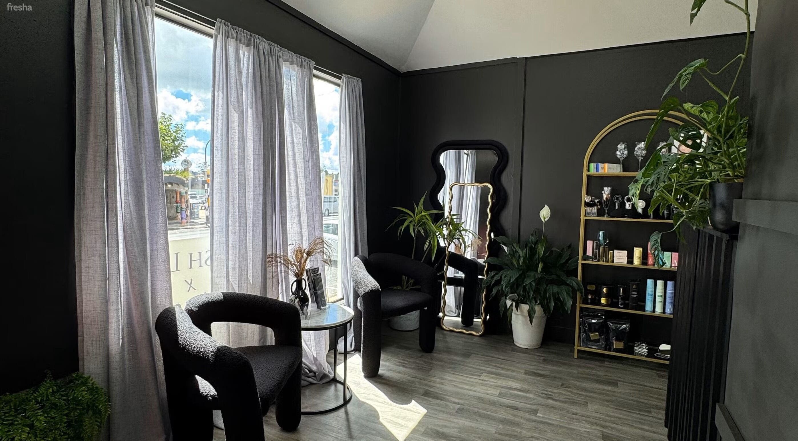 Elegant interior of Aio Skin (Friday Glow) in Kawakawa, Northland, NZ featuring modern black chairs and plants.