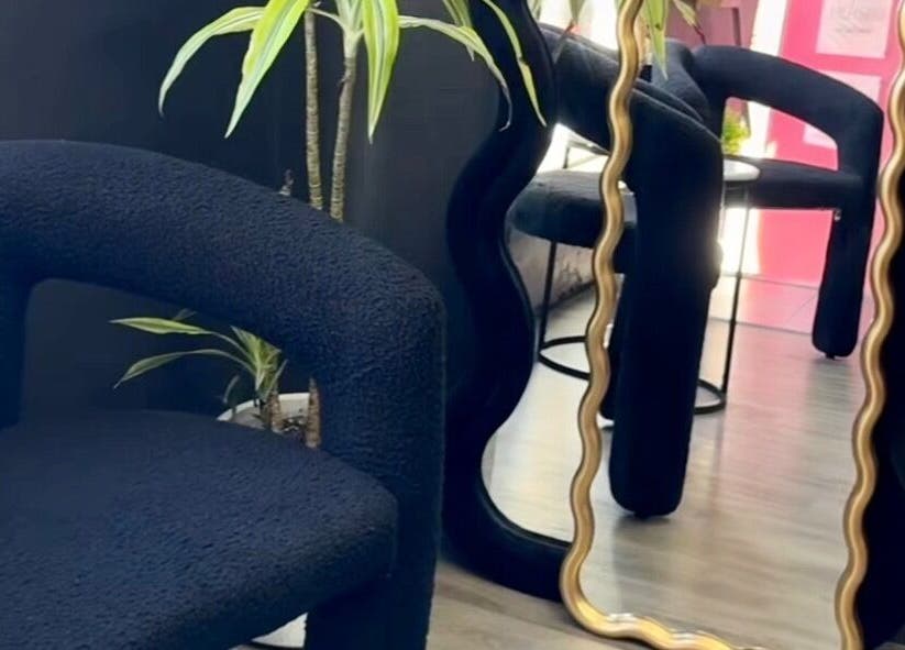 Stylish waiting area at Aio Skin (Friday Glow), Kawakawa, Northland, NZ with unique mirror and modern chair.