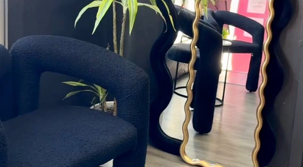 Stylish waiting area at Aio Skin (Friday Glow), Kawakawa, Northland, NZ with unique mirror and modern chair.