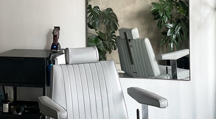 Modern salon chair at Brother Wolf St Kilda, Melbourne, Victoria, AU, with sleek design and green plants.
