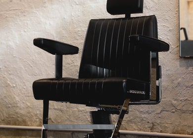Elegant black barber chair at Brother Wolf Fitzroy, Melbourne, Victoria, AU, showcasing style and comfort.