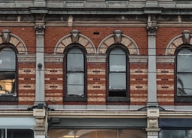Red brick facade of Brother Wolf Fitzroy in Melbourne, Victoria, AU, showcasing elegant arched windows.