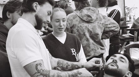Barber trimming beard at Brother Wolf Prahran, Prahran, Victoria, AU amidst a lively atmosphere.