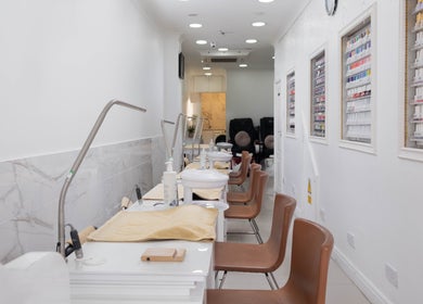 Interior view of Brick Lane Nail Spa in London, England, GB, showcasing manicure stations and gel colors.