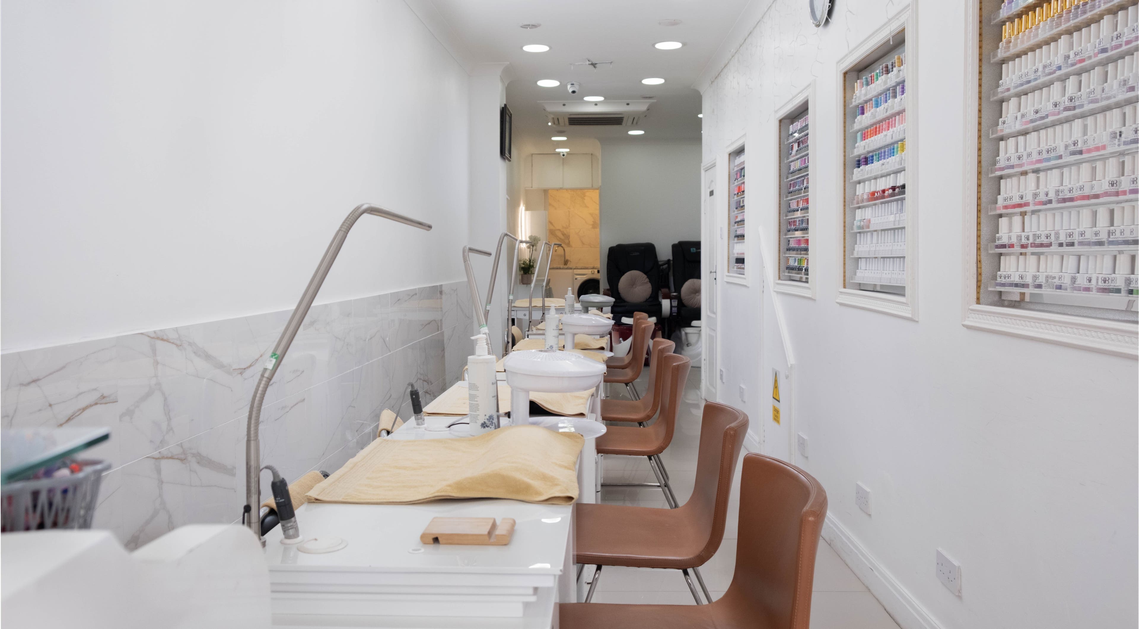Interior view of Brick Lane Nail Spa in London, England, GB, showcasing manicure stations and gel colors.