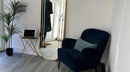 Stylish lounge area at Nurse Injector Michelle, Lowestoft, England, GB with plush chair and large mirror.
