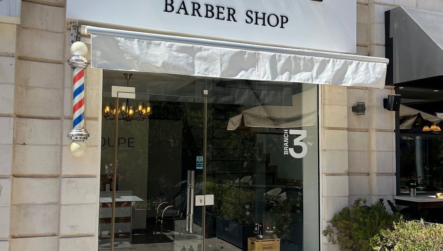 Entrance of Le Coupe 3 barber shop in عمّان, محافظة العاصمة, JO featuring a classic barber pole.