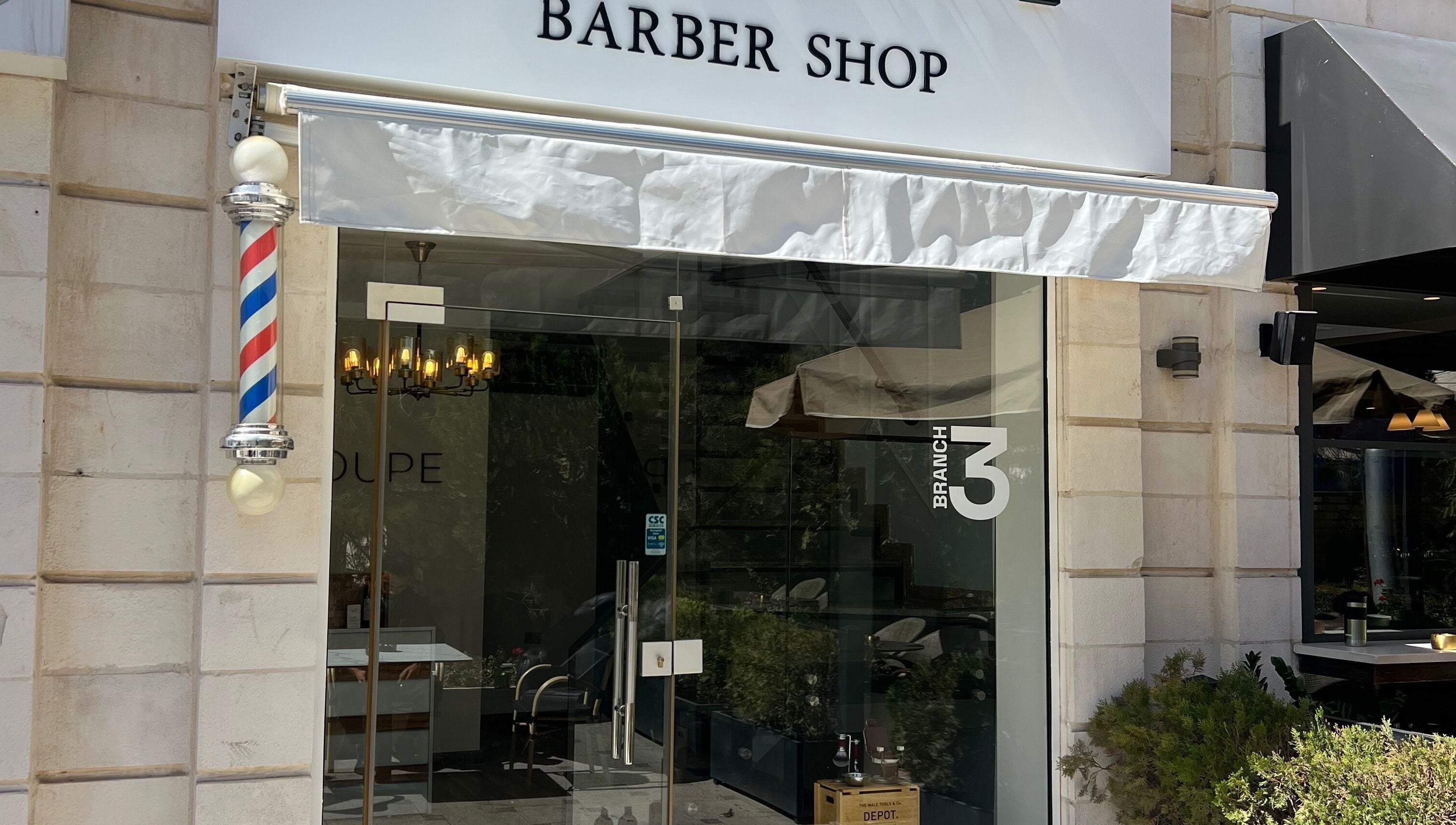 Entrance of Le Coupe 3 barber shop in عمّان, محافظة العاصمة, JO featuring a classic barber pole.