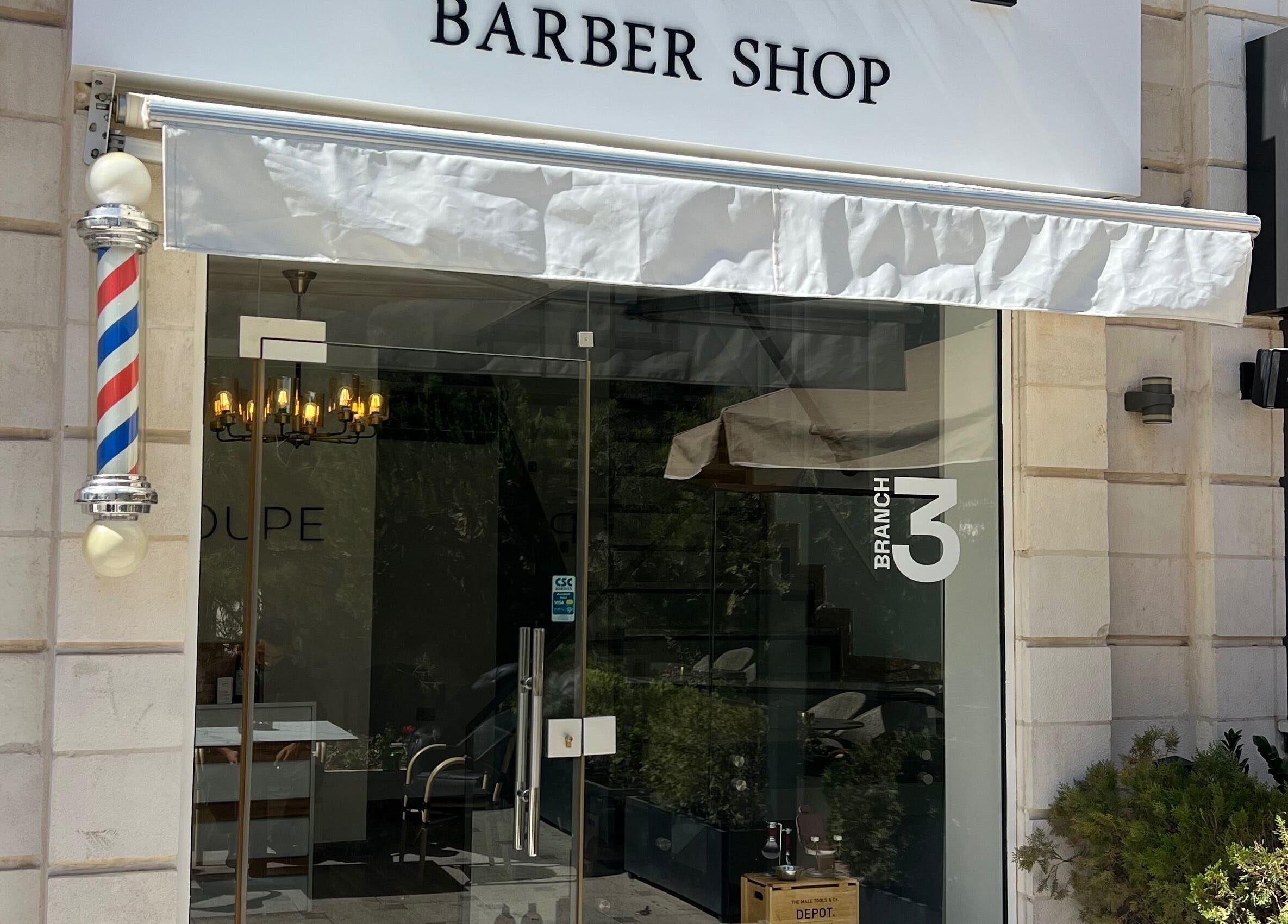 Entrance of Le Coupe 3 barber shop in عمّان, محافظة العاصمة, JO featuring a classic barber pole.