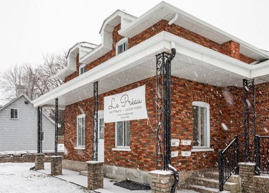 Le Préau Coiffure - Esthétique sous la neige à Laval, Québec, CA, façade en briques rouges.