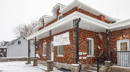 Le Préau Coiffure - Esthétique sous la neige à Laval, Québec, CA, façade en briques rouges.