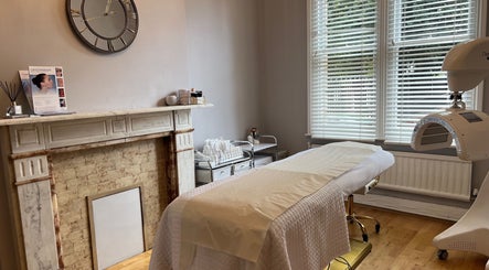 Serene therapy room at The London Road Clinic, Newark-on-Trent, England, featuring cozy fireplace and treatment bed.