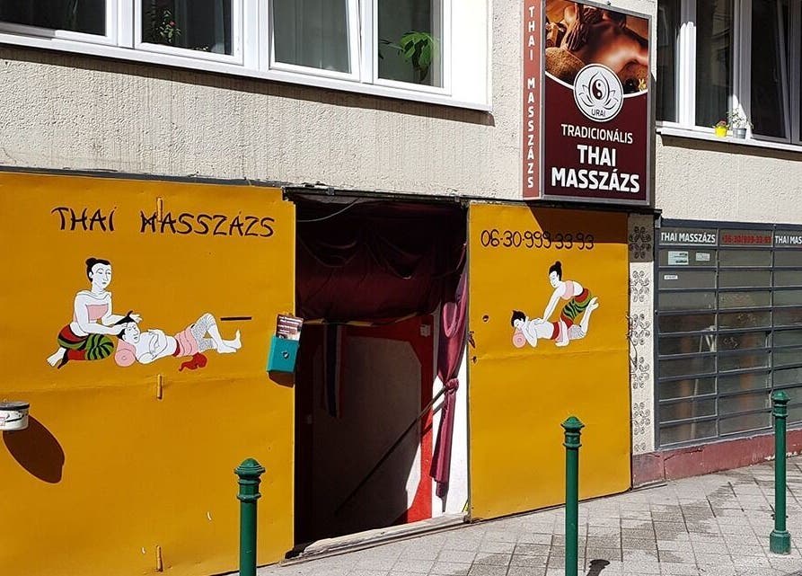 Entrance to Urai Thai Massage in Budapest, HU featuring traditional Thai massage artwork on the storefront.