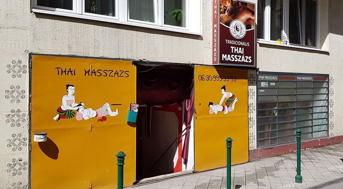 Entrance to Urai Thai Massage in Budapest, HU featuring traditional Thai massage artwork on the storefront.