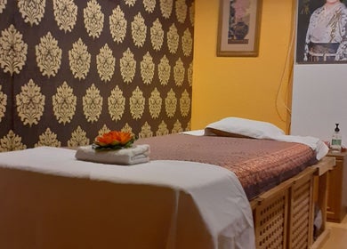 Serene massage room at Urai Thai Massage, Budapest, HU with a beautifully decorated bed and soft lighting.
