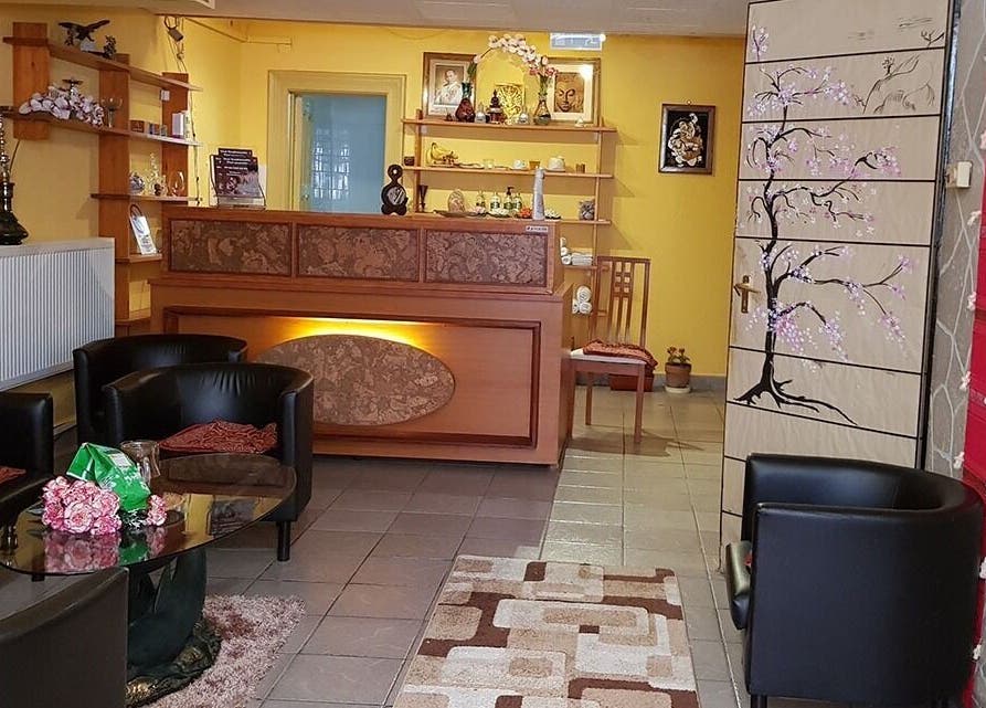 Reception area of Urai Thai Massage in Budapest, HU, featuring elegant chairs and a warm, inviting ambiance.