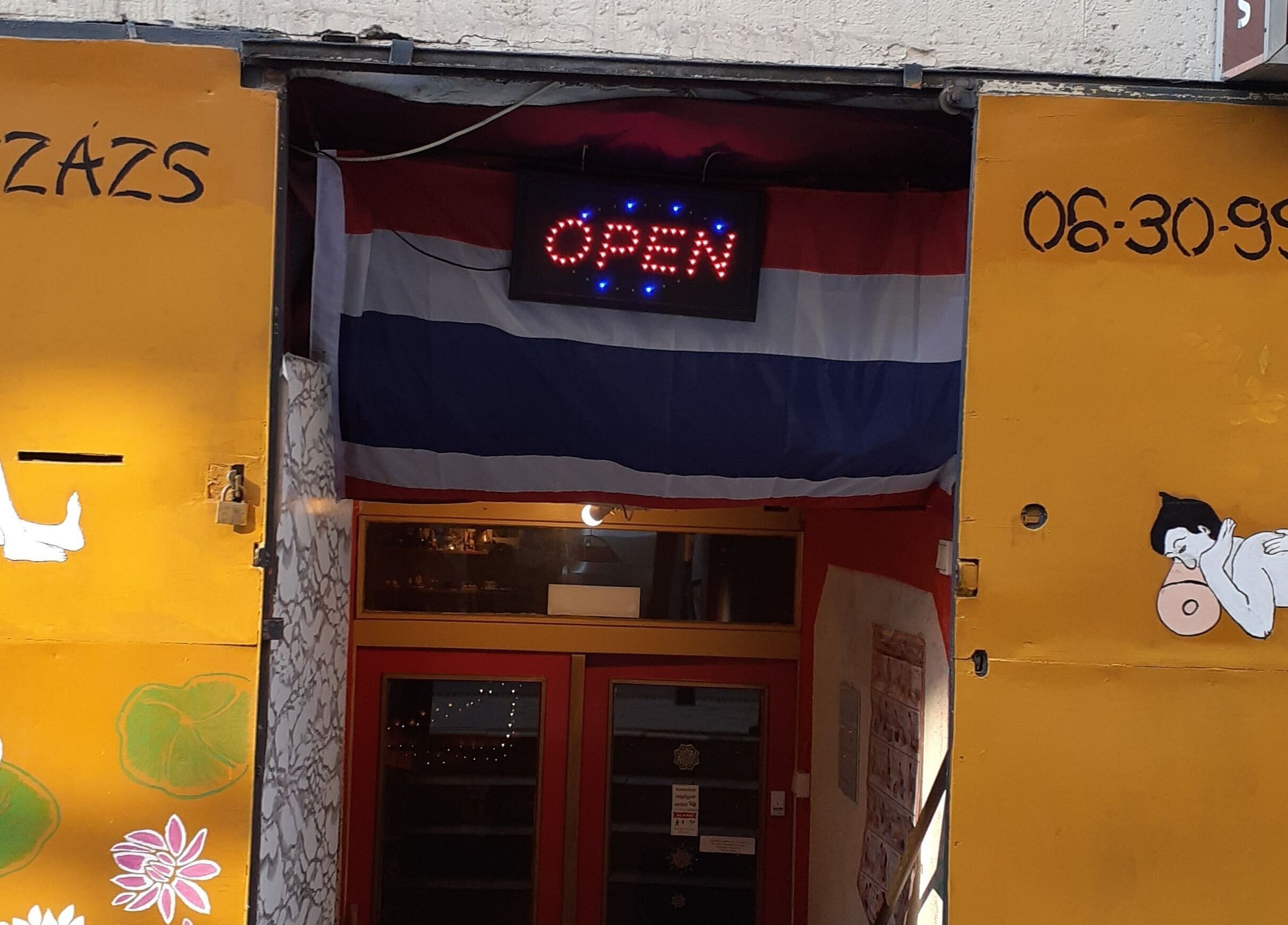 Entrance of Urai Thai Massage with open sign and Thai art in Budapest, HU.
