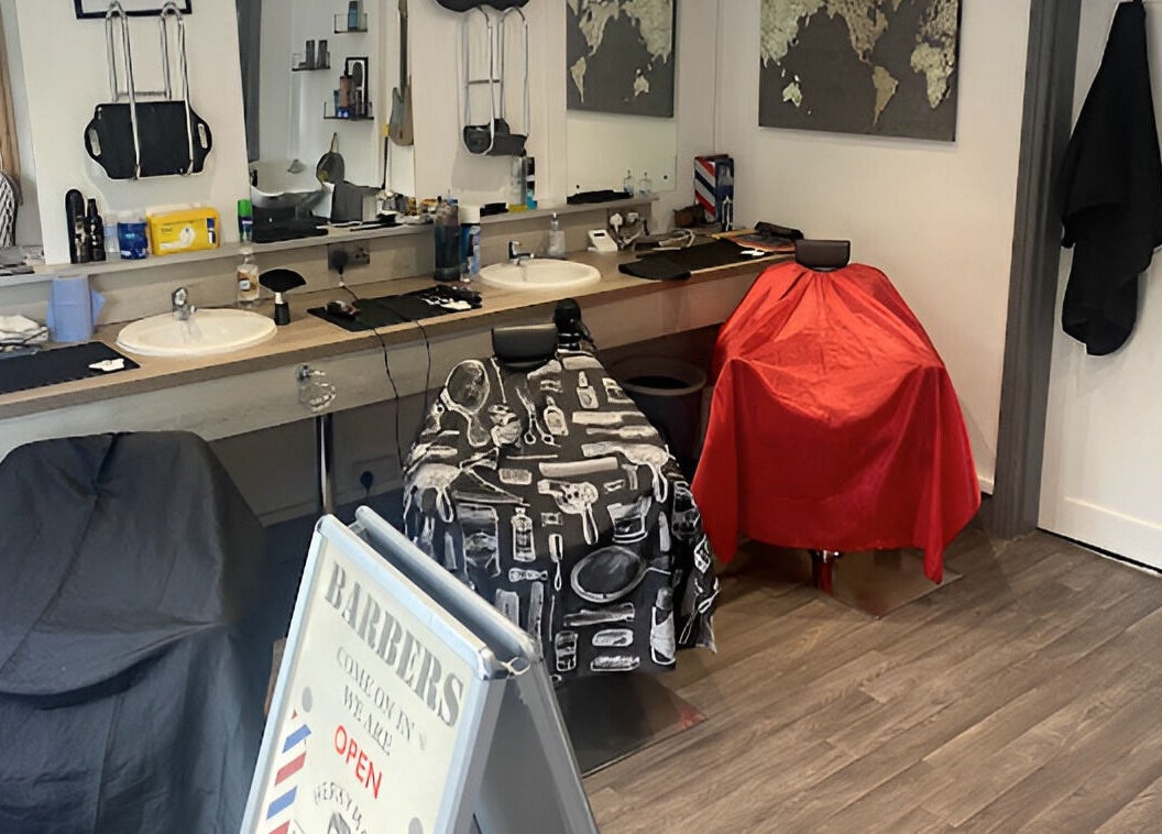 Modern barbershop at Herkymoo Herstmonceux in Herstmonceux, England, GB, featuring stylish decor and barber chairs.