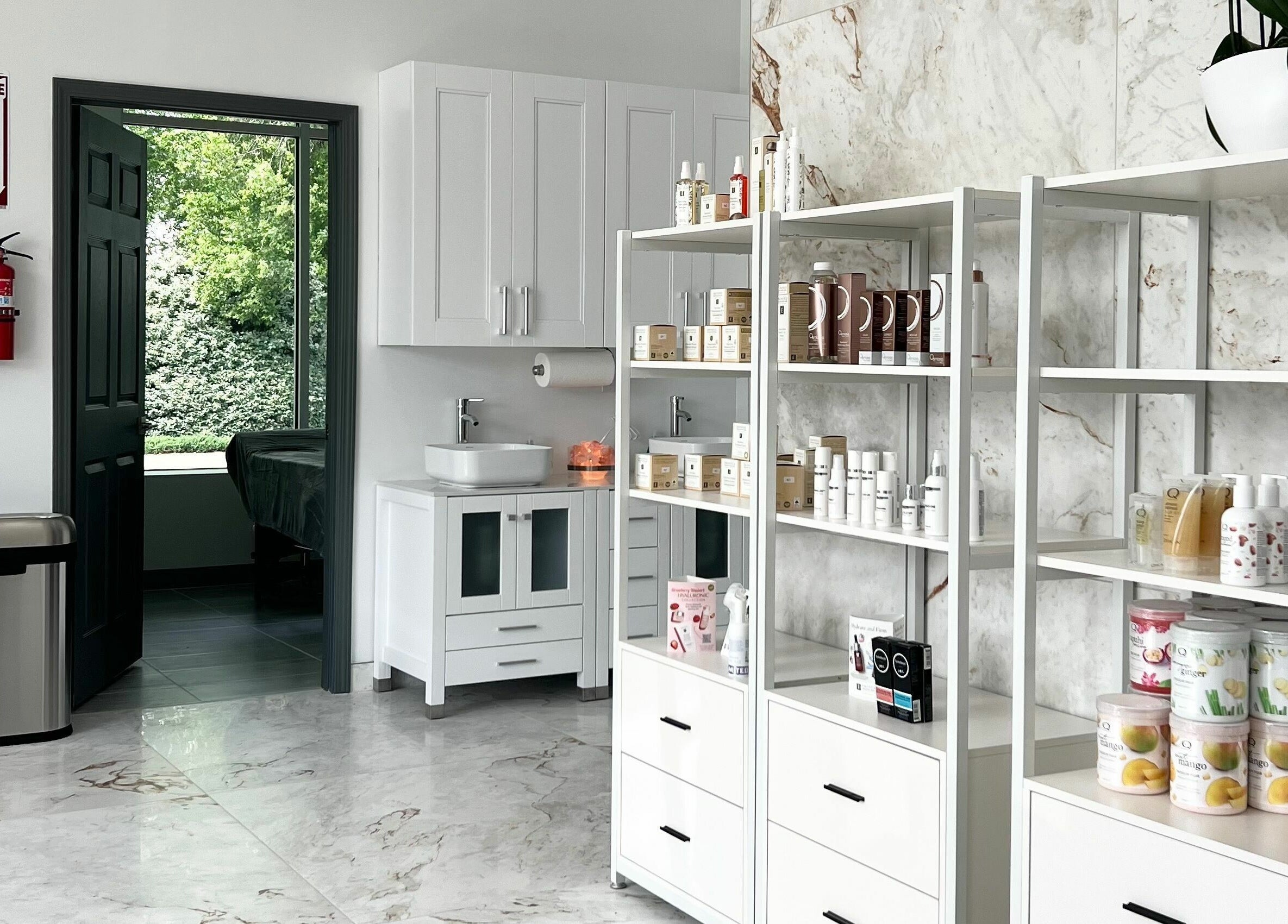 Bright interior of Vogue Lashes and Spa in Virginia Beach, showcasing products on sleek white shelves.